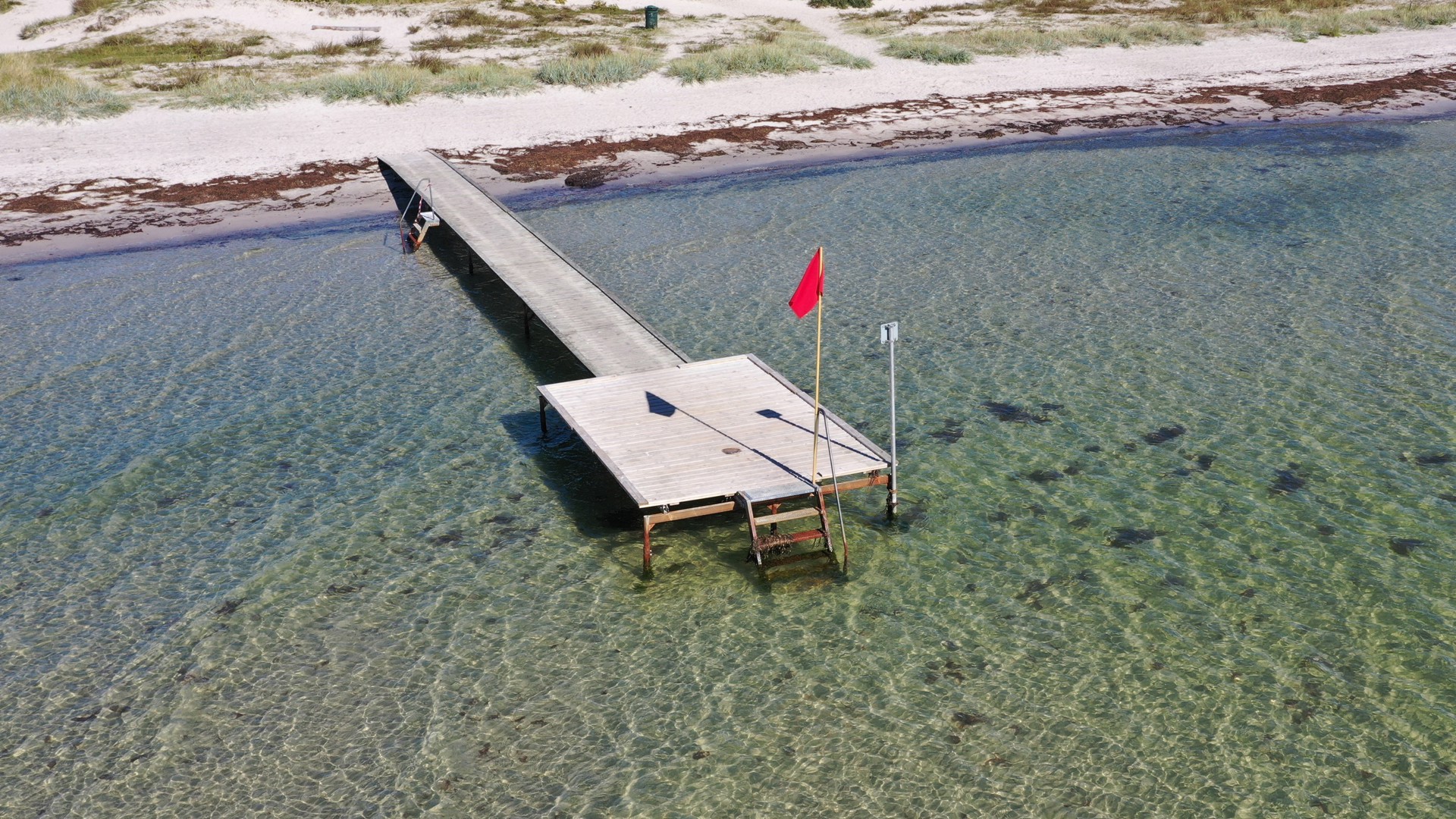 Rødt flag ved Greve strand